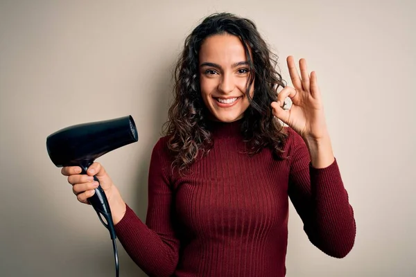 若いです美しいです女性とともに巻き毛を使用してヘアドライヤー隔離された白い背景の上に指でOkサインを行います 優れたシンボル — ストック写真