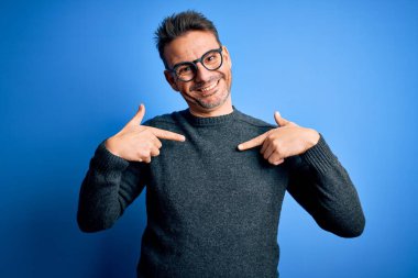 Mavi arka planda sıradan süveter ve gözlük takan genç yakışıklı bir adam. Kendine güvenen, yüzünde gülümseme olan, kendini gururlu ve mutlu gösteren biri..