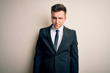 Zarif takım elbiseli ve kravatlı genç yakışıklı iş adamı izole edilmiş arka plan şüphecisi ve gergin, sorun yüzünden somurtuyor. Negatif kişi.