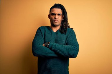 Sarışın, yeşil kazaklı, kuşkucu ve gergin, suratında çapraz kollu tasvip etmeyen bir ifade olan Afro-Amerikan genç bir adam. Negatif kişi.