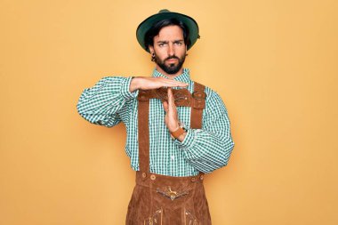 Almanya festivali için geleneksel Alman Ekim Festivali kıyafeti giyen yakışıklı bir adam. Elleriyle, hayal kırıklığına uğramış ve ciddi bir yüz ifadesiyle mola veriyor.