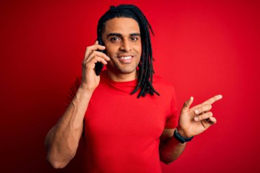 Afrika kökenli Afro-Amerikan bir adam Rastalı konuşuyordu. Akıllı telefonuyla çok mutlu bir şekilde el ve parmak kaldırıyordu.