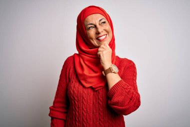 Orta yaşlı esmer kadın izole edilmiş beyaz arka plan üzerine geleneksel başörtüsü takıyor kameraya bakıyor kollarını kavuşturup el ve çenesini kaldırarak gülümsüyor. Olumlu düşünüyorum..