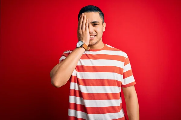 Jovem Brasileiro Vestindo Camiseta Listrada Casual Sobre Fundo Vermelho Isolado — Fotografia de Stock