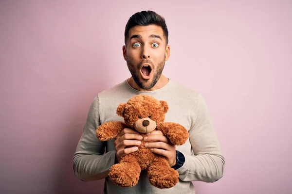 Jovem Homem Bonito Segurando Ursinho Pelúcia Sobre Fundo Rosa Isolado — Fotografia de Stock