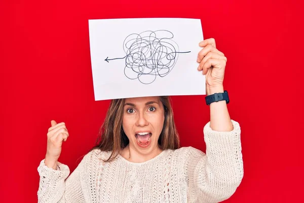 Young Beautiful Blonde Woman Holding Picture Chaos Stress Pointing Thumb — Stock Photo, Image