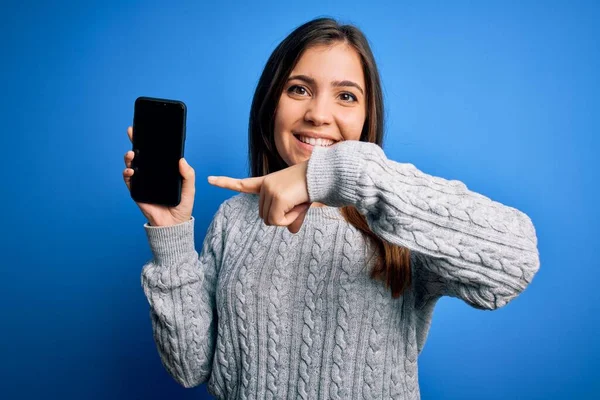 若いです女性ショー空白のスマートフォン画面上の青隔離された背景非常に幸せなポインティングとともに手と指 — ストック写真