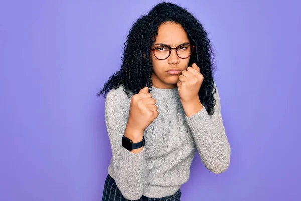 Młoda Afroamerykanka Ubrana Luźny Sweter Okulary Fioletowym Tle Gotowa Walki — Zdjęcie stockowe
