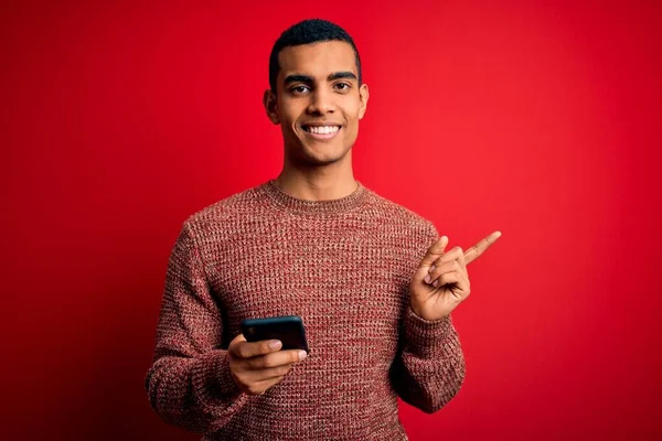 英俊的非洲裔美国人 在红色背景下用智能手机交谈 非常快乐 手指手画脚 — 图库照片