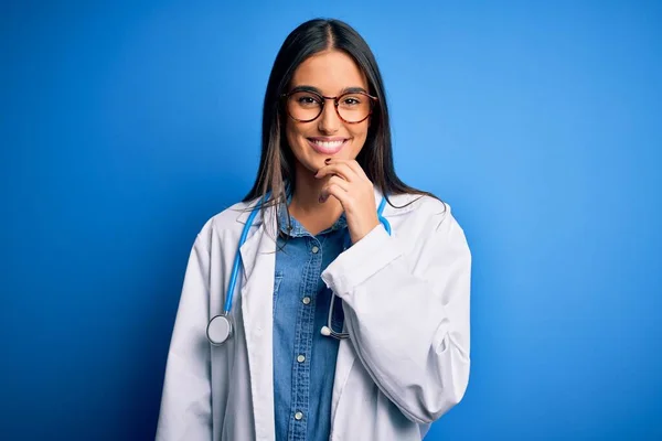 Mladá Krásná Lékařka Stetoskopem Brýlemi Přes Modré Pozadí Vypadá Sebevědomě — Stock fotografie