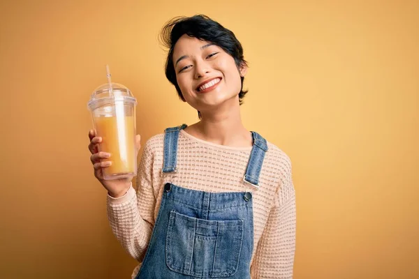 Giovane Bella Cinese Che Beve Sano Succo Arancia Sfondo Giallo — Foto Stock