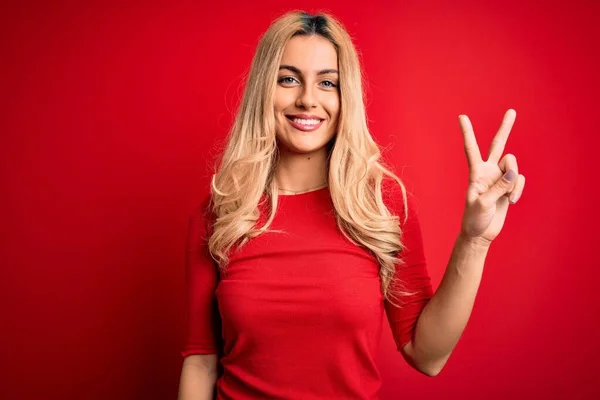 Jovem Mulher Loira Bonita Vestindo Camiseta Casual Sobre Fundo Vermelho — Fotografia de Stock