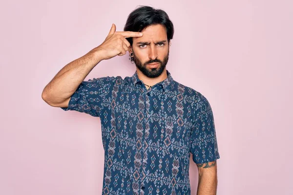 Pembe arka planda hippi tarzı giyinmiş genç, Latin asıllı bohem bir adam alnında sivilceden mutsuz, siyah noktalı çirkin bir enfeksiyon olduğunu gösteriyor. Sivilce ve deri problemi