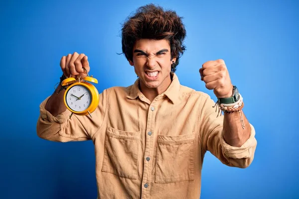 Young Handsome Man Holding Alarm Clock Standing Isolated Blue Background — Stock Photo, Image