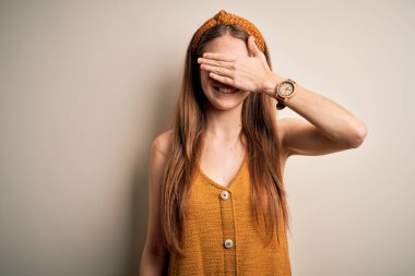 Genç, kızıl saçlı, sıradan tişörtler giyen ve sarı arka planda tebessüm takan güzel bir kadın. Gülümsüyor ve şaşırmak için gözleri kapayarak gülüyor. Kör kavram.