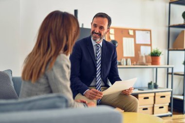 Mutlu ve kendinden emin gülümseyen iki orta yaşlı iş adamı. Ofiste evrakları tutarken gülümseme ile birlikte çalışmak.