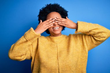 Kıvırcık saçlı, sarı kazak giyen, elleri gülücüklü, neşeli gözleri olan güzel Afro-Amerikan bir kadın. Kör kavram.