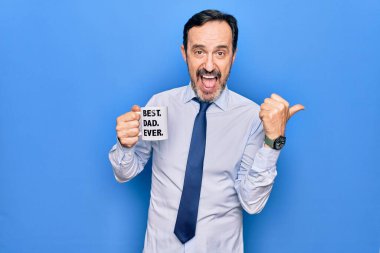 Orta yaşlı, zarif bir iş adamı, en iyi babasıyla bir fincan kahve içiyor. Mesajı başparmağıyla yukarı kaldırıyor ve ağzı açık bir şekilde gülümsüyor.