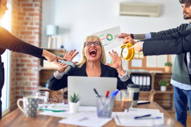 Group of business workers working together. Partners stressing one of them at the office