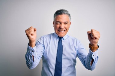 Orta yaşlı, yakışıklı, gri saçlı, şık gömlek giyen, kravat takan kızgın ve kızgın yumruk kaldıran bir iş adamı öfkeyle bağırırken sinirli ve öfkeli. Öfke ve agresif kavram.