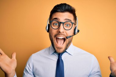 Çağrı merkezinden gelen müşteri hizmetleri kulaklığı takan genç bir işletmeci deliliği kutluyor ve kollarını kaldırıp heyecanla haykırarak başarıdan hayrete düşüyor. Kazanan konsept