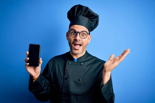 Giovane Bel Cuoco Uomo Indossa Uniforme Cappello Tenendo Smartphone Sfondo — Foto Stock