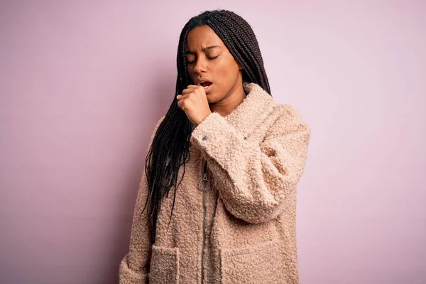 年轻的非洲裔美国女人穿着时尚的冬季外套 而不是粉色孤立的背景 感觉不舒服 咳嗽是感冒或支气管炎的症状 保健概念 — 图库照片