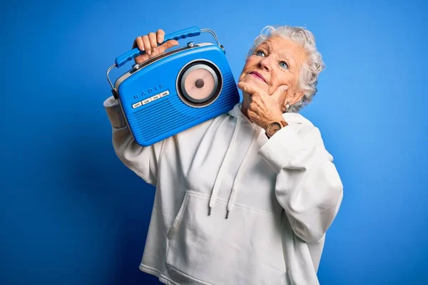 Senior Mooie Vrouw Met Vintage Radio Staande Geïsoleerde Blauwe Achtergrond — Stockfoto