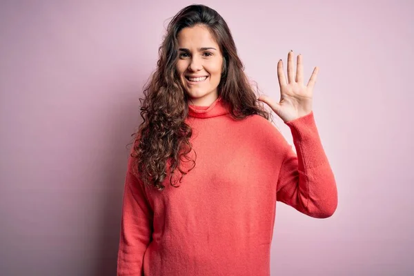 Junge Schöne Frau Mit Lockigem Haar Trägt Rollkragenpullover Über Rosa — Stockfoto