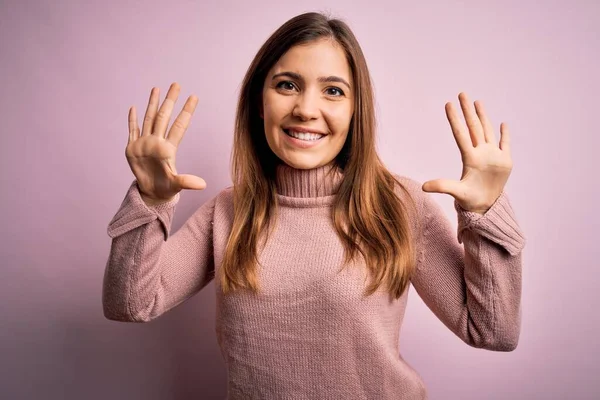 Schöne Junge Frau Trägt Rollkragenpullover Über Rosa Hintergrund Zeigt Und — Stockfoto