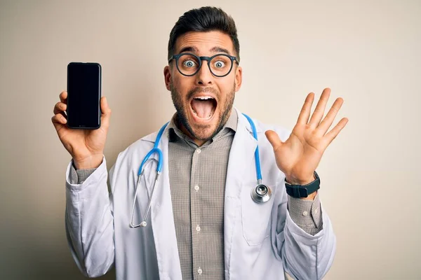 Młody Lekarz Noszący Stetoskop Pokazujący Ekran Smartfona Odosobnionym Tle Bardzo — Zdjęcie stockowe