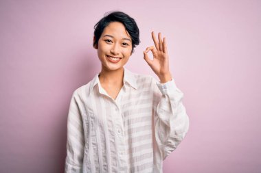 İzole edilmiş pembe arka planda duran ve el ve parmaklarıyla 