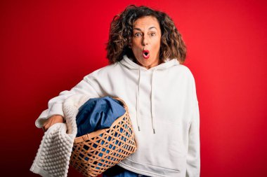 Orta yaşlı güzel bir kadın elinde sepet tutuyordu. Kırmızı arka planda giysiler vardı. Şaşırmış bir yüzle korkmuş ve korku ifadesinden korkmuştu.