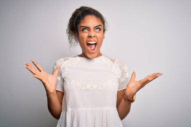 Beyaz arka plan üzerinde sıradan tişörtler giyen genç ve güzel Afro-Amerikalı kız. Deli gibi bağırıyor ve agresif bir ifade ve kollarla bağırıyor. Hayal kırıklığı konsepti.