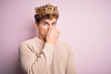 Kıvırcık saçlı genç bir adam pembe arka planda kralın altın tacını takıyor. Kokuşmuş, iğrenç, dayanılmaz bir koku alıyor. Parmakları burnunda nefesini tutuyor. Kötü kokuyor.