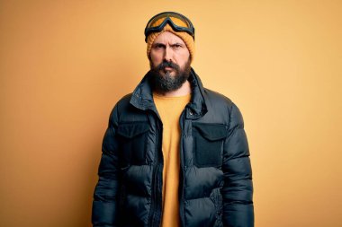 Sakallı, kar bezi ve kayak gözlüğü takan yakışıklı, kel kayakçı şüpheci ve gergin, sorun yüzünden surat asıyor. Negatif kişi.