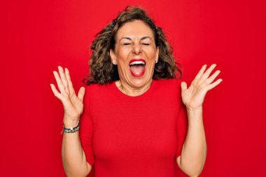 Orta yaşlı, esmer bir kadın kırmızı arka planda dikilmiş kolları havada ve gözleri kapalı heyecanla haykırarak başarıyı kutluyor. Kazanan konsept