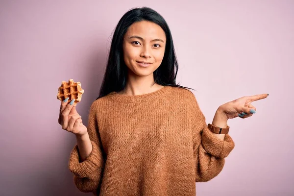 Genç Güzel Çinli Bir Kadın Elinde Waffle Tutarken Pembe Arka — Stok fotoğraf