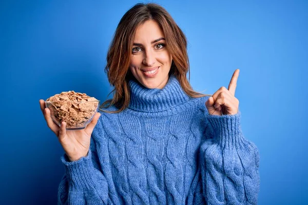 Young Beautiful Brunette Woman Holding Bowl Healthy Cornflakes Cereals Surprised — Stock Photo, Image