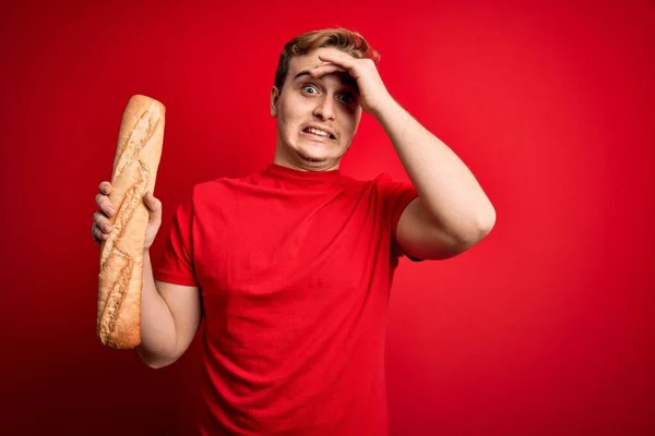 Joven Pelirrojo Guapo Sosteniendo Pan Fresco Casero Sobre Fondo Rojo — Foto de Stock