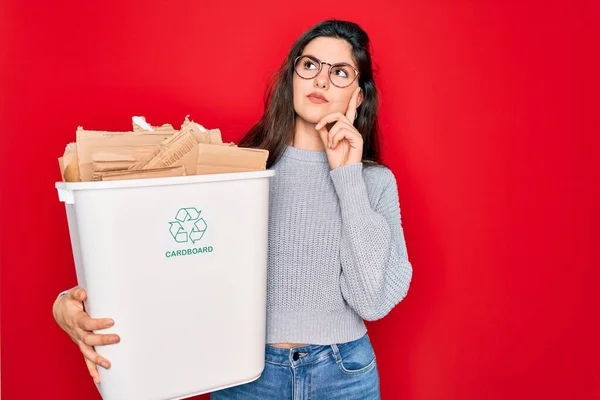 リサイクル段ボール容器を持っている若い美しい女性エコ環境のためのリサイクル深刻な顔の質問について考えて 非常に混乱したアイデア — ストック写真