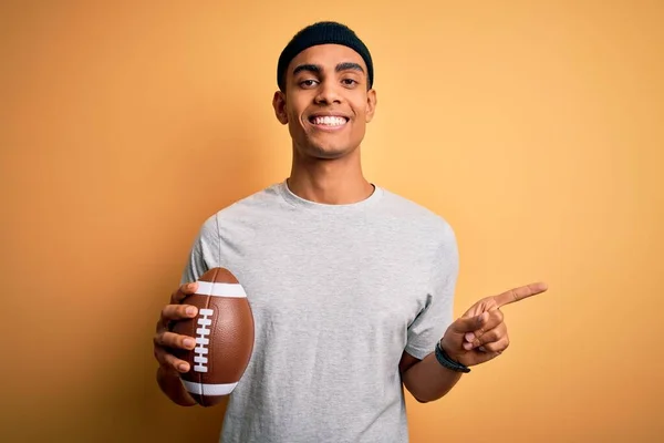 Joven Hombre Afroamericano Guapo Sosteniendo Pelota Rugby Sobre Fondo Amarillo — Foto de Stock