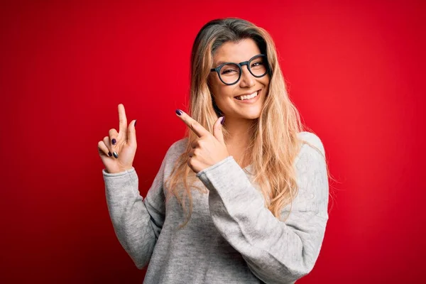 Jovem Mulher Loira Bonita Vestindo Suéter Óculos Sobre Fundo Vermelho — Fotografia de Stock