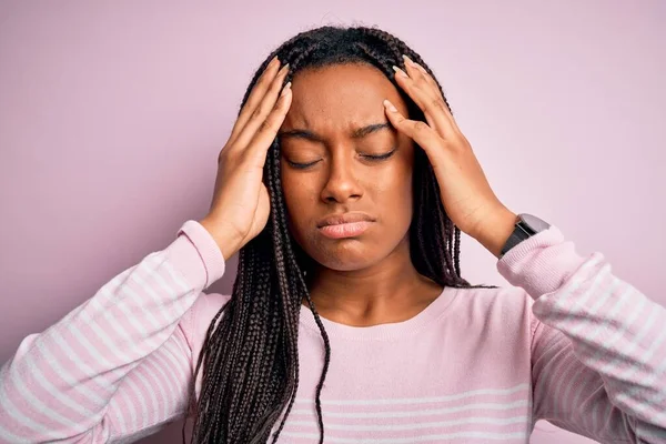 痛みや片頭痛のために必死に頭痛やストレスに苦しんで隔離された背景の上にピンクのセーターを着て若いアフリカ系アメリカ人女性のクローズアップ 手を頭に — ストック写真