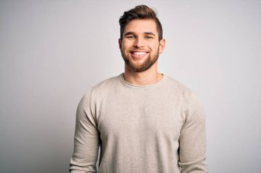 Sakallı, mavi gözlü, sıradan bir süveter giyen mutlu ve havalı bir gülümsemesi olan genç, yakışıklı sarışın bir adam. Şanslı kişi..