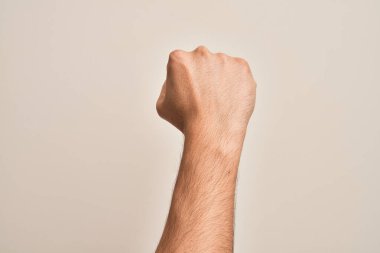 Beyaz arka planda protesto ve devrim hareketi yapan, güç ve güç gösterisi yapan beyaz tenli bir gencin eli.