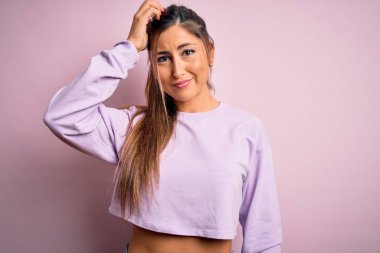 Pembe izole edilmiş arka plan kafa karışıklığı ve soru sorusu üzerine kazak giyen genç ve güzel bir bayan. Şüpheyle kararsız, kafa kafaya düşünerek. Düşünceli kavram.