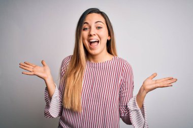 Mavi gözlü, genç, sarışın bir kadın beyaz arka plan üzerinde ince tişört giyiyor. Çılgınlığı kutluyor ve başarıyı hayrete düşürüyor. Kolları havada ve gözleri açık, heyecanlı bir şekilde çığlık atıyor. Kazanan konsept