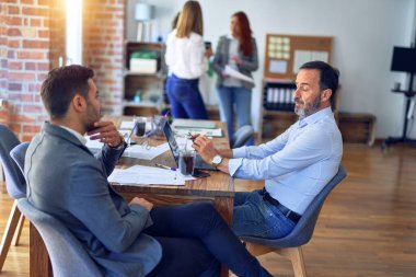 Handsome businessmen sitting and speaking relaxed at the office