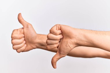 İzole edilmiş beyaz arka plan üzerinde parmaklarını gösteren beyaz bir gencin eli. Onaylamıyor ve onaylıyor. Karışık duygular.